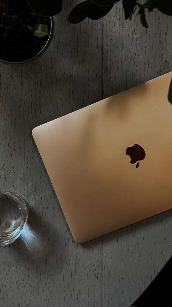 A minimalist desk setup featuring a laptop and water, setting the ideal scene for a dedicated business coach